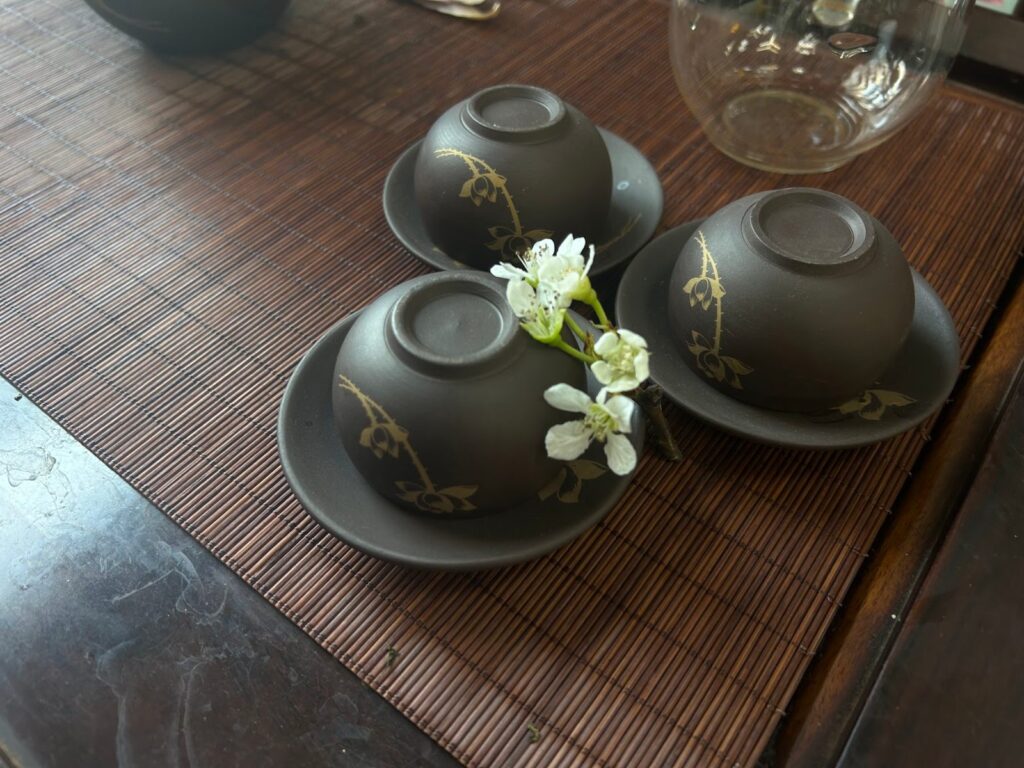 Ấm chén và hoa trắng trên khay trà