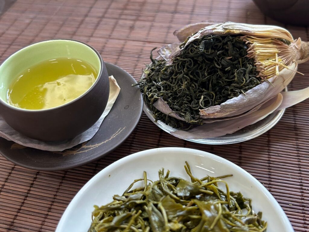 Chén trà cạnh trà sen và đĩa trà khô