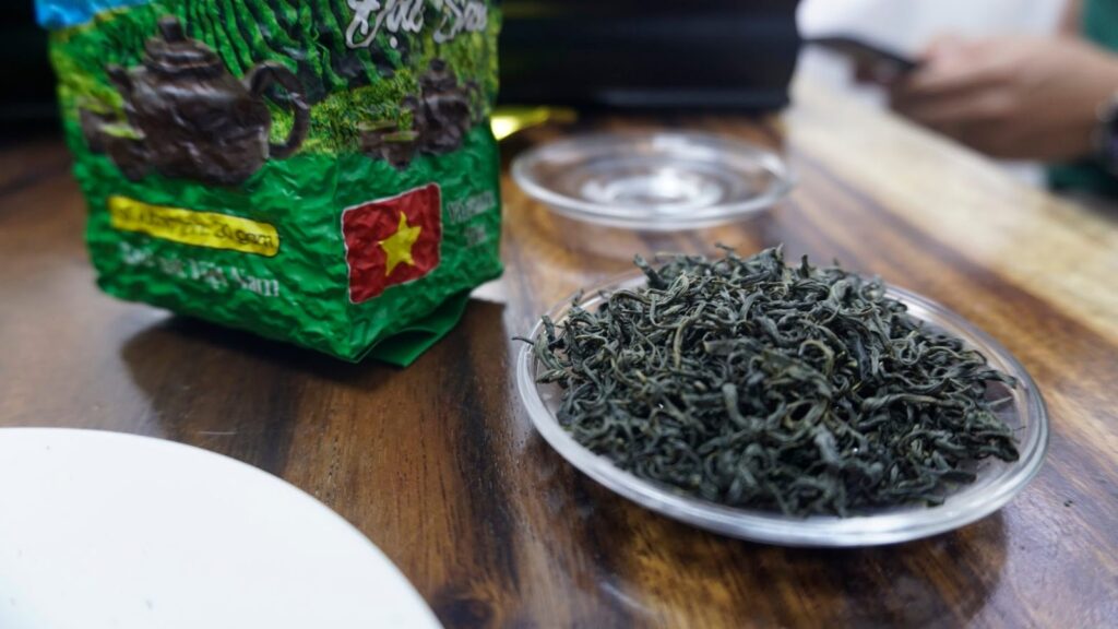 Giá sỉ Trà Bắc Thái Nguyên cho quán cà phê, trà đá, nhà hàng: cách chọn hạng và nhận bảng giá Đĩa trà khô trên quầy bàn gỗ