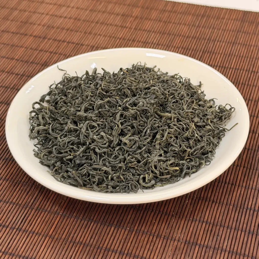 Trà nõn khô sợi xoăn trên đĩa sứ trắng, nguyên liệu trà xanh pha chế