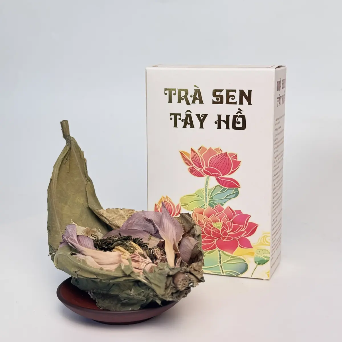 Trà sen Tây Hồ lấy sỉ: bông sen ướp trà đặt bên hộp Trà Sen Tây Hồ