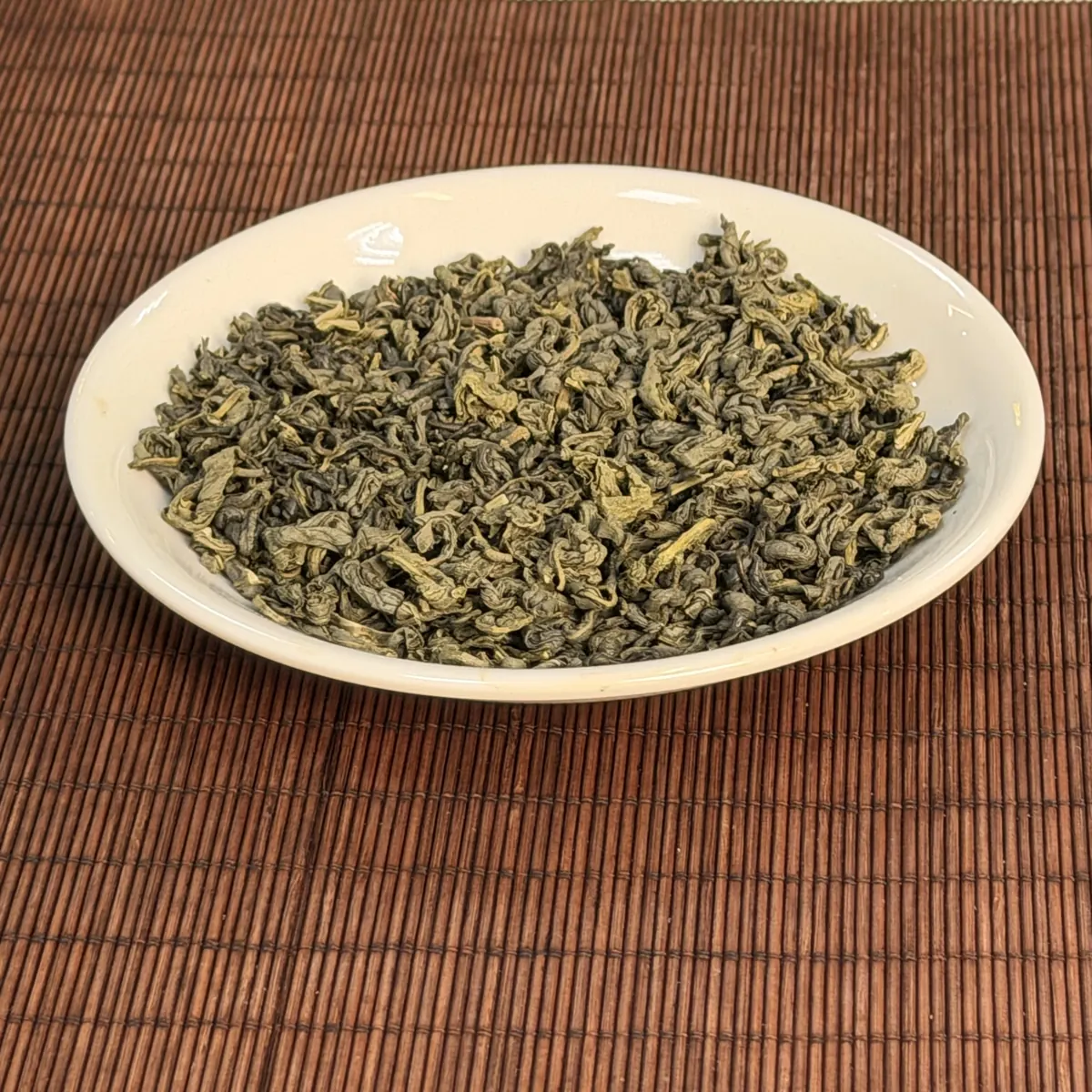 Trà xanh khô cánh xoăn chặt trên đĩa sứ dùng pha trà đá cho quán cafe